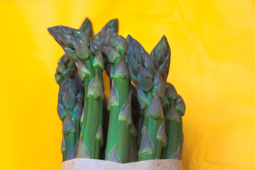 Asparagus. Fresh green asparagus on a bright yellow clear background. 