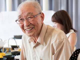 An old man talking animatedly at a family event