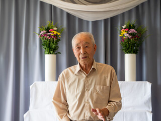 An elderly Asian man delivery a speech at a family event