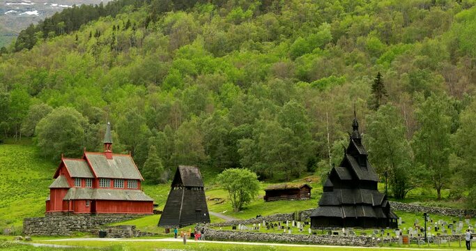 Borgund, Norway. People Walking Near Famous Norwegian Landmark Stavkirke An Old Wooden Triple Nave Stave Church In Summer Day. Panorama, Panoramic View