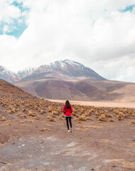 Tourist woman hiking landscape mountain lake. Dry, Barren desert, snowcapped mountains wilderness. Mountain range view. Salt Flats, Uyuni, Bolivia. Copy space, Rocks, blue sky, nature, hiker
