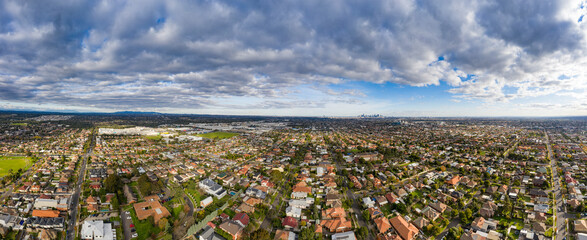 Aerial 180 degree view of the Melbourne suburb of Preston Victoria on a cloudy autumn day. The city of Melbourne can be seen in the distance.
