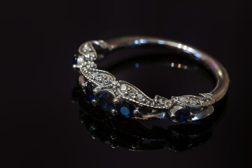 Engagement ring with sapphires on a black background.