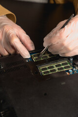 A close-up of the master technician clears the dust from an old laptop. computer repair