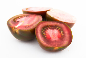 black halves of tomatoes on white background