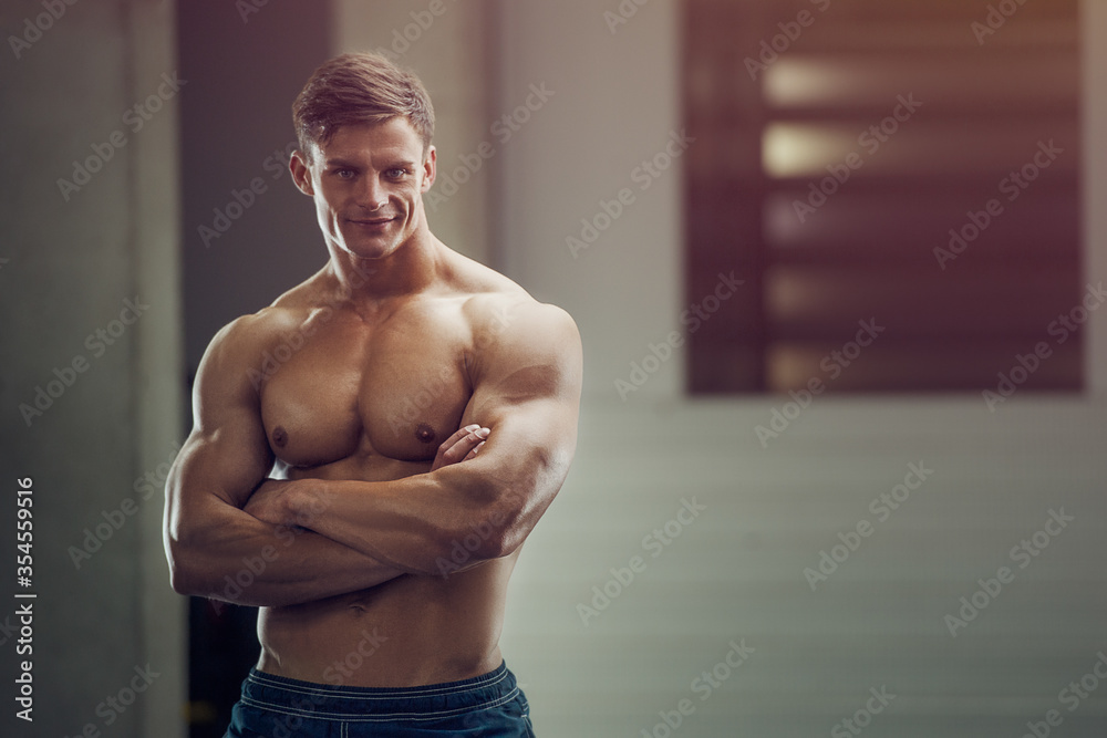 Wall mural bodybuilder handsome strong athletic rough man pumping up muscles workout fitness and bodybuilding h