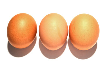 Three brown eggs on a white background. Poultry product.