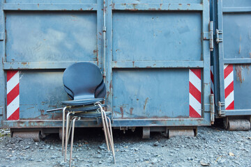 Stühle als Sperrmüll vor Bauschuttcontainer auf Industrie Gelände