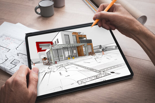 Tablette numérique tenue en main par un architecte qui travaille et réalise l'esquisse d'un projet de construction d'une maison en 3D