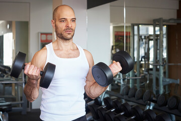 Man training with dumbbell workout in the gym