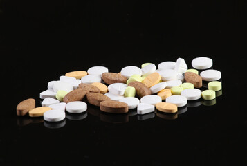 Many different pills close-up on a black background