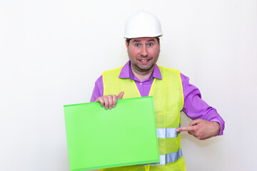 Portrait of curious surprised architect in a construction helmet holding a folder, free place mock up banner advertisement.Studio shoot.