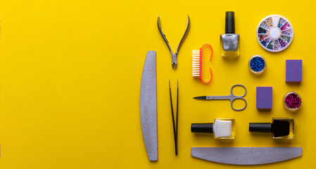 manicure and pedicure tools and accessories on yellow background top view.