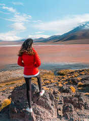 Fototapeta premium Tourist, Red Lake mountain landscape, Bolivia. Woman with Beautiful colored water, with mountains background and unique scenic view. Flamingos in the lake. Shot in Uyuni, Salar de Uyuni, South America