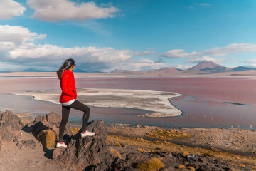 Tourist, Red Lake mountain landscape, Bolivia. Woman with Beautiful colored water, with mountains background and unique scenic view. Flamingos in the lake. Shot in Uyuni, Salar de Uyuni, South America