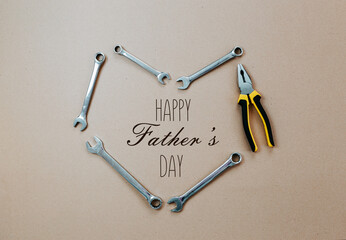 Tools top view on craft paper. Father's day card with tools. Open wrenches and plier in shape of...