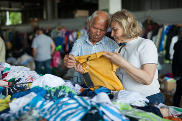 Elderly parents buy clothes for grandchildren on street market
