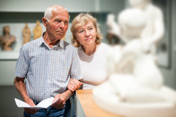 Couple holding brochure at museum