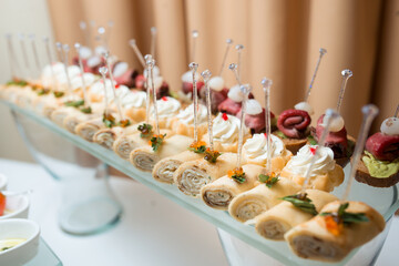 Сatering banquet table with different snacks and desserts