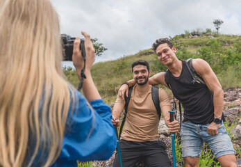 Woman taking a photo of two hiker man between a vacation mountain journey