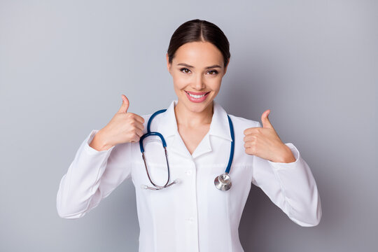 Photo of attractive cheerful family doc experienced professional tell patient good news covid test negative result thumbs up wear medical uniform coat stethoscope isolated grey background