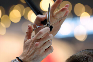 Scissors in hand of hairdresser ready to cut the client at the hair salon