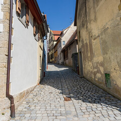 Fototapeta na wymiar narrow cobbled street with old houses in the old German town of Rothenburg ob der Tauber