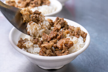 Braised meat rice, stewed beef over cooked rice in Tainan, Taiwan. Taiwanese famous traditional street food delicacy. Travel design concept, closeup.