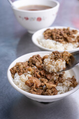 Braised meat rice, stewed beef over cooked rice in Tainan, Taiwan. Taiwanese famous traditional street food delicacy. Travel design concept, closeup.