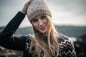 Portrait of young smiling woman wearing a handmade knitted hat
