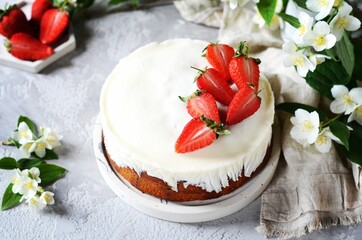 Strawberry cake with cream in a plate on a gray background