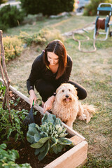 Woman gardening in company of her dog