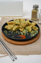 Delicious chiken chop with seaweed seasoning. Chicken chop on black plate.