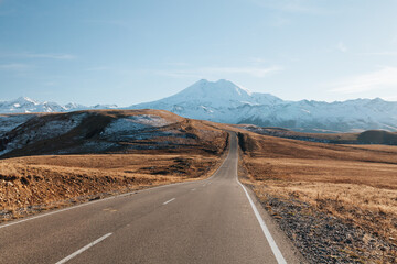 Road overlooking the the highest mountain in Europe – isolated Mount Elbrus – with blue sky in the background