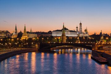 Fototapeta na wymiar Classic view to the Moscow Kremlin and Bolshoy Kamenny Bridge above the river at half an hour before dawn with blue sky and bright orange horizon