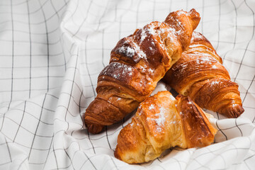 Close up of delicious butter croissants with sugar powder on white cloth