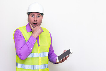 Construction builder wearing helmet yellow protective vest using wireless tablet and showing like...
