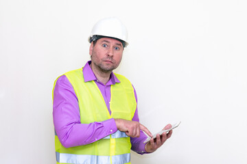 Construction builder wearing helmet yellow protective vest using wireless tablet and showing like or thumbs-up shocked poke up shows to you and victory  gesture isolated on white background.