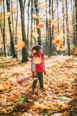 little beautiful girl loves autumn, walks in autumn forest and smiles