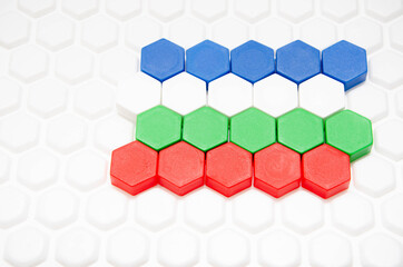 Children's mosaic in macro. Hexagonal puzzle in the form of a honeycomb, element, detail for laying out a picture. Lines of the same colors of details side view, top view on a white background