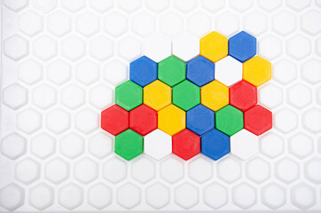Children's mosaic in macro. Hexagonal puzzle in the form of a honeycomb, element, detail for laying out a picture. Lines of the same colors of details side view, top view on a white background