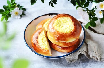 Homemade buns with cottage cheese (cheesecakes) in a dish on a gray background, Russian cuisine