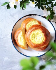 Homemade buns with cottage cheese (cheesecakes) in a dish on a gray background, Russian cuisine