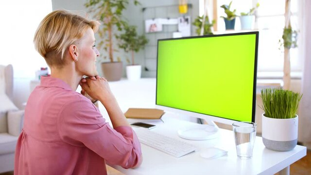 Businesswoman with computer having video call indoors in office, keyable screen.