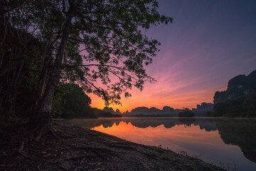 Obraz premium Natural background of a large reservoir in Krabi,Thailand(Nong Thale)atmosphere surrounded by mountains,trees of various sizes, blown through the wind,blurred cool during the day,a viewpoint of travel