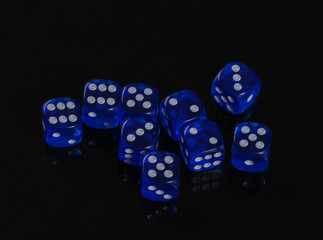 Blue dice on a black background. Game addiction. Luck