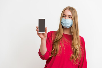 woman in medical mask looking at smartphone with blank screen isolated on white