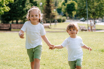 Fototapeta premium Blond children play and have fun on a sunny day in the park..