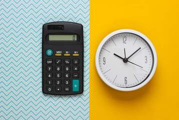 Time to invest. White clock and calculator on yellow background. Minimalistic studio shot. Top view