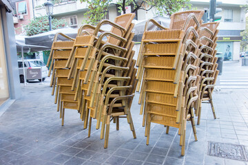 stacked wicker chairs on the street